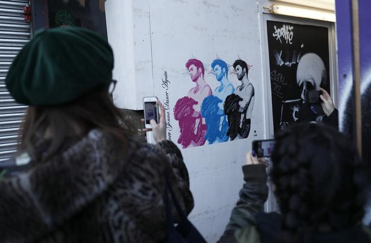 © Reuters. Pessoas fotografam mural retratando o cantor George Michael, em Londres