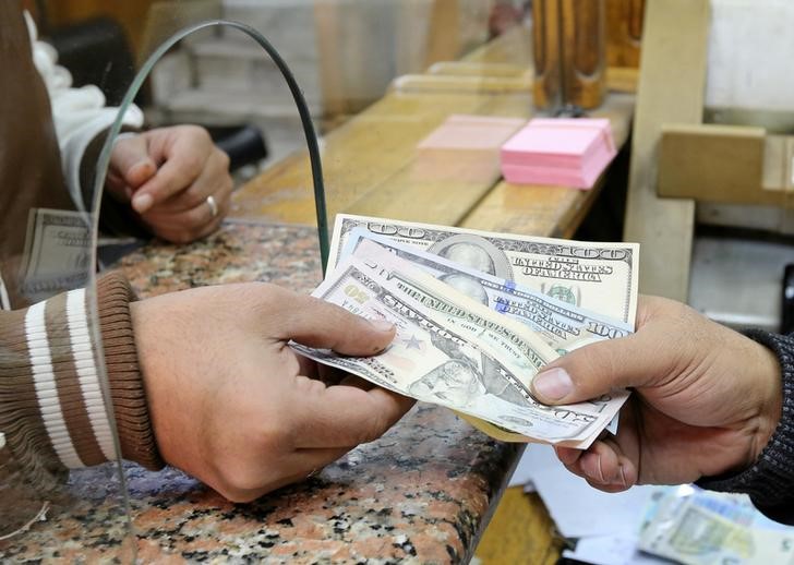 © Reuters. Cliente troca notas de dólar em casa de câmbio no Cairo, Egito