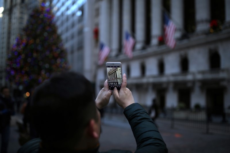 © Reuters. A tourist takes a photo outside the New York Stock Exchange (NYSE) in Manhattan