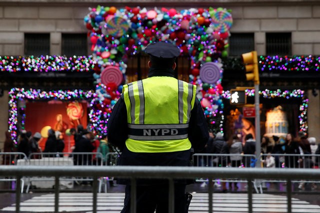 © Reuters. A member of the New York Police Department stands watch outside Saks Fifth Avenue on Christmas Eve in Manhattan, New York City, U.S.