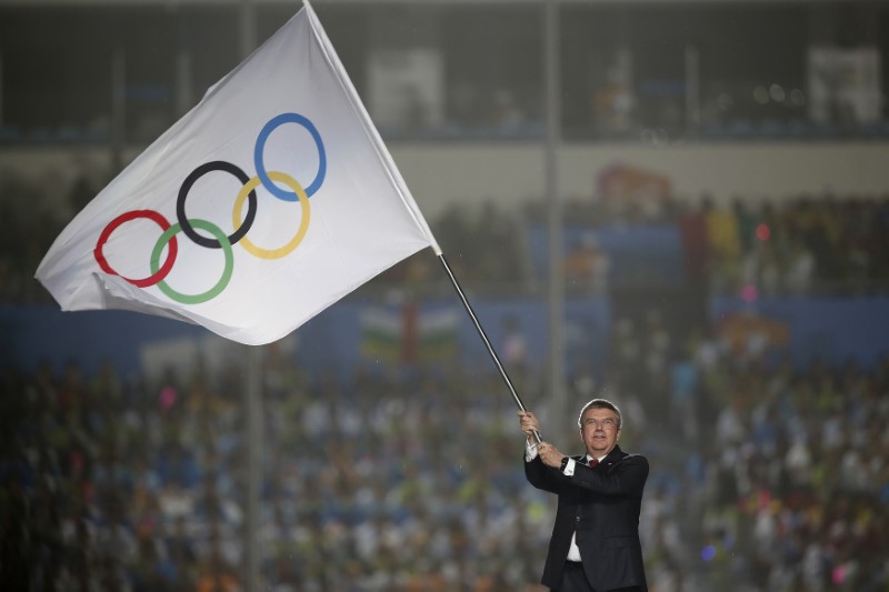 © Reuters. International Olympic Committee President Thomas Bach waves the Olympic flag during the closing ceremony of the 2014 Nanjing Youth Olympic Games in Nanjing,