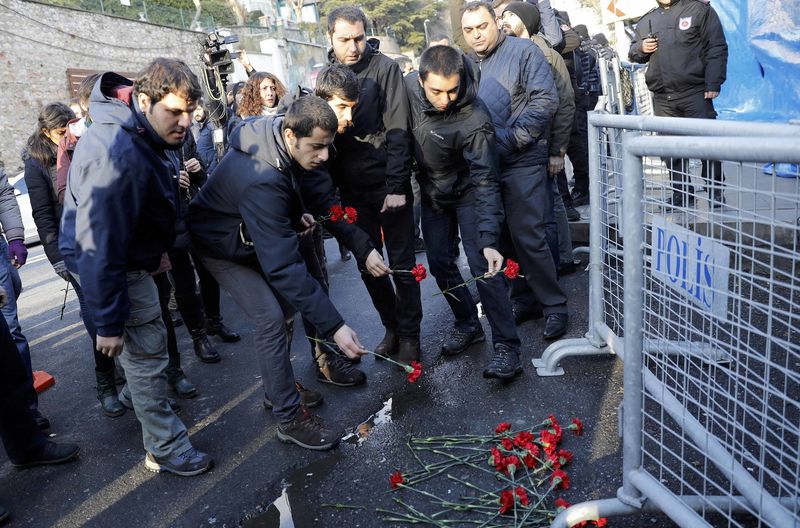 © Reuters. Men lay flowers outisde the Reina nightclub by the Bosphorus, which was attacked by a gunman, in Istanbul