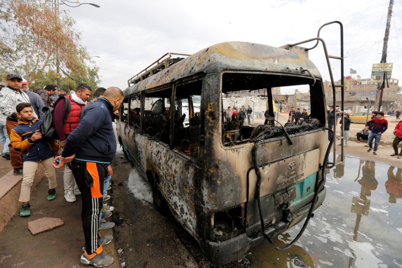 © Reuters. Pessoas observam veículo queimado no local de explosão de um carro-bomba em Sadr City, um bairro de Bagdá