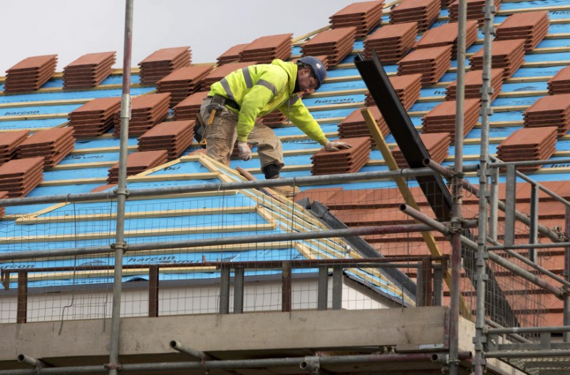 © Reuters. File photo of a builder working on the roof of a new residential property development in north London