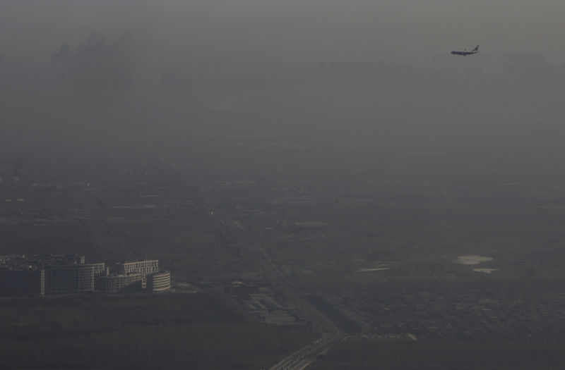 © Reuters. Avião sobrevoa Pequim em meio a neblina intensa