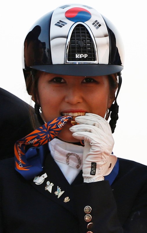 © Reuters. FILE PHOTO: South Korea's Chung Yoo-ra poses after winning the equestrian Dressage Team competition during the 17th Asian Games in Incheon