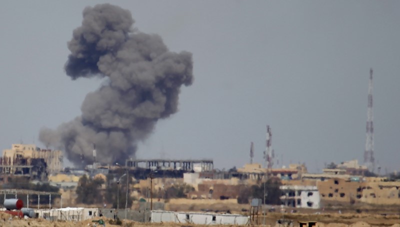 © Reuters. A plume of smoke rises above a building during an air strike in Tikrit