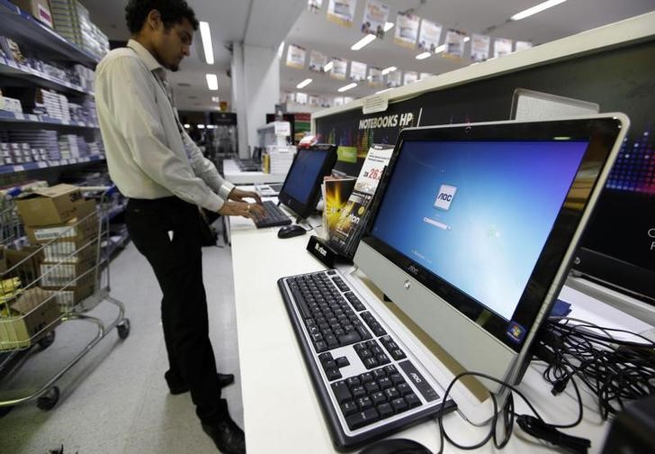 © Reuters. Vendedor utiliza computador em supermercado de São Paulo