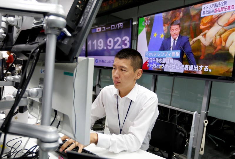 © Reuters. Employee of a foreign exchange trading company works in front of monitors showing  Italian Prime Minister Matteo Renzi on TV news, and the Japanese yen's exchange rate against the euro in Tokyo