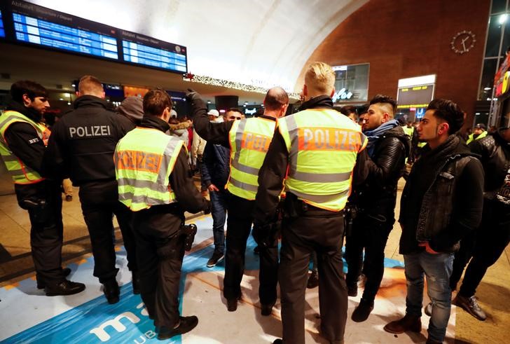 © Reuters. Police officers of Germany's federal police Bundespolizei check young men at Cologne's main railways station following New Year celebrations