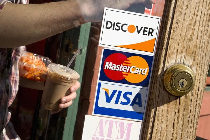 © Reuters. A coffee shop displays signs for Visa, MasterCard and Discover in Washington
