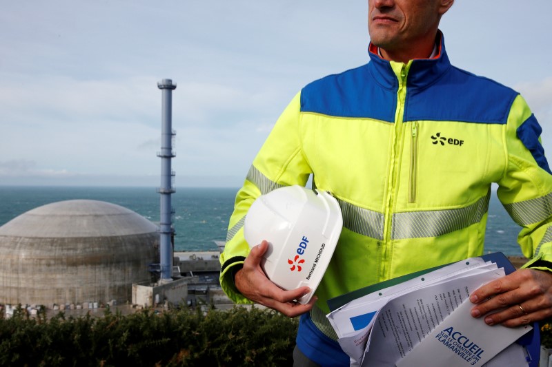 © Reuters. FILE PHOTO   An EDF employee stands in front of the construction site of the third-generation European Pressurised Water nuclear reactor (EPR) in Flamanville