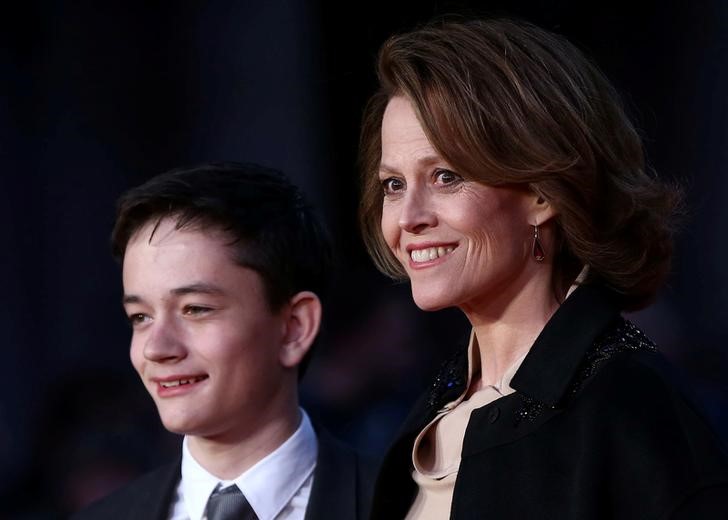 © Reuters. Atriz Sigourney Weaver  posa para foto ao lado de ator Lewis MacDougall na chegada de ambos para a exibição de “Sete Minutos depois da Meia-Noite”  em Londres