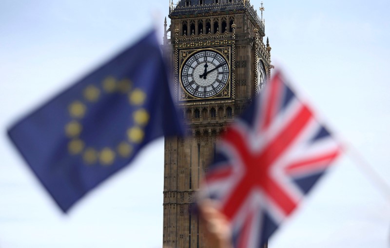 © Reuters. Participants hold a British Union flag and an EU flag during a pro-EU referendum event at Parliament Square in London