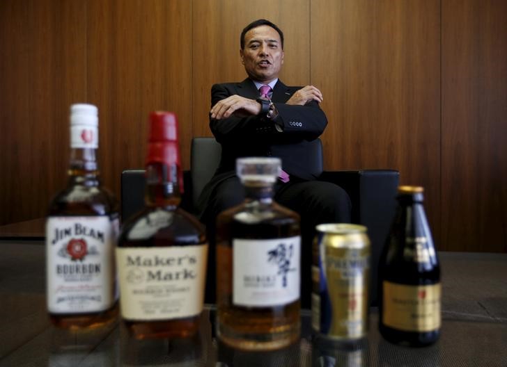 © Reuters. Suntory Holdings Ltd's President and CEO Takeshi Niinami speaks behind the company's alcoholic beverages during an interview with Reuters at the company headquarters in Tokyo