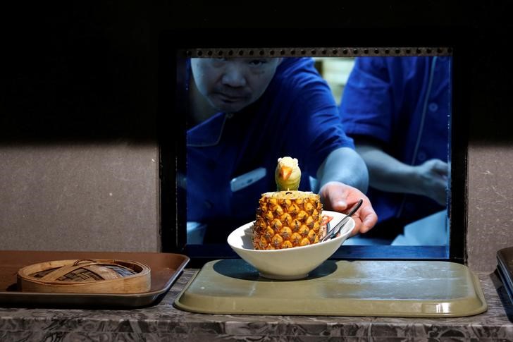 © Reuters. A cook delivers a fried rice with pineapple from the kitchen at Dim Sum Icon restaurant in Hong Kong