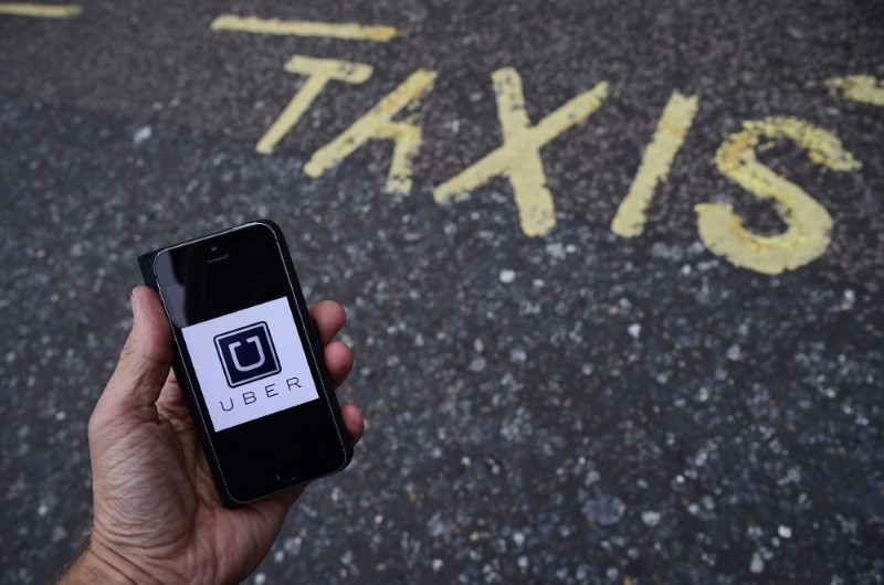 © Reuters. A photo illustration shows the Uber app logo displayed on a mobile telephone, as it is held up for a posed photograph in central London