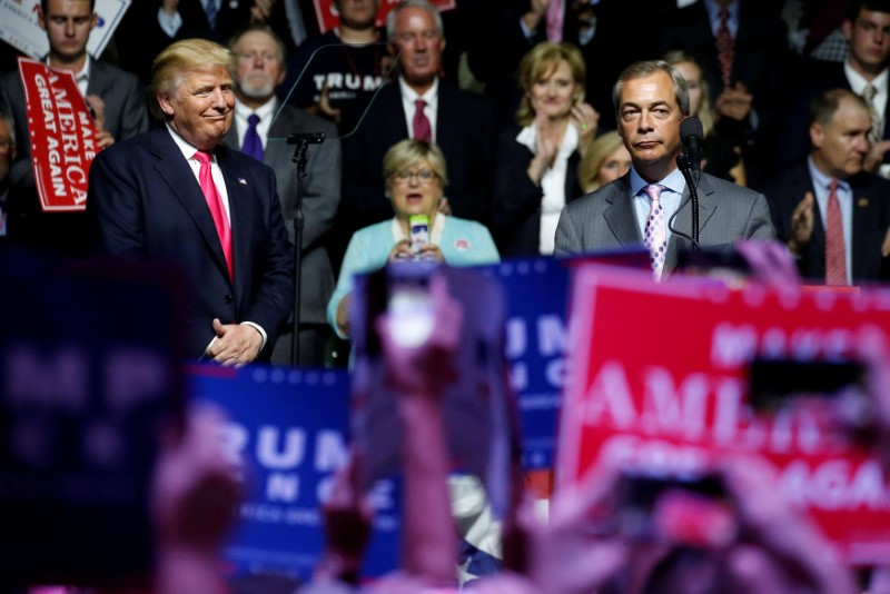 © Reuters. Republican presidential nominee Donald Trump watches as Member of the European Parliament Nigel Farage speaks at a campaign rally in Jackson