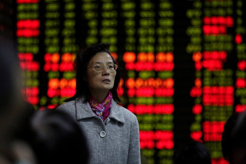 © Reuters. An investor looks at an electronic board showing stock information at a brokerage house in Shanghai