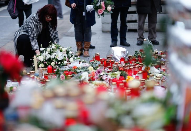 © Reuters. Woman lays flowers near the Christmas market at Breitscheid square in Berlin