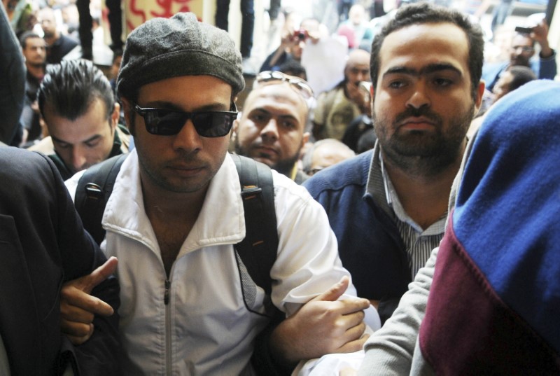 © Reuters. Mohamed Adel is seen with Ahmed Maher, founder and former leader of the "April 6" movement, when Maher turned himself in at Abddein court in Cairo