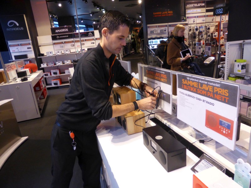 © Reuters. Worker Nilsen arranges digital radios in an Expert City electronics shop in Oslo