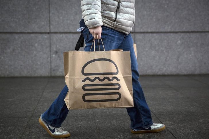 © Reuters. A man carries away bags of Shake Shack in New York