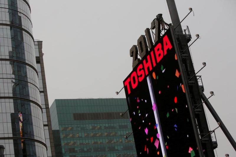 © Reuters. FILE PHOTO -  Workers prepare the New Year's eve numerals above a Toshiba sign in Times Square Manhattan, New York City