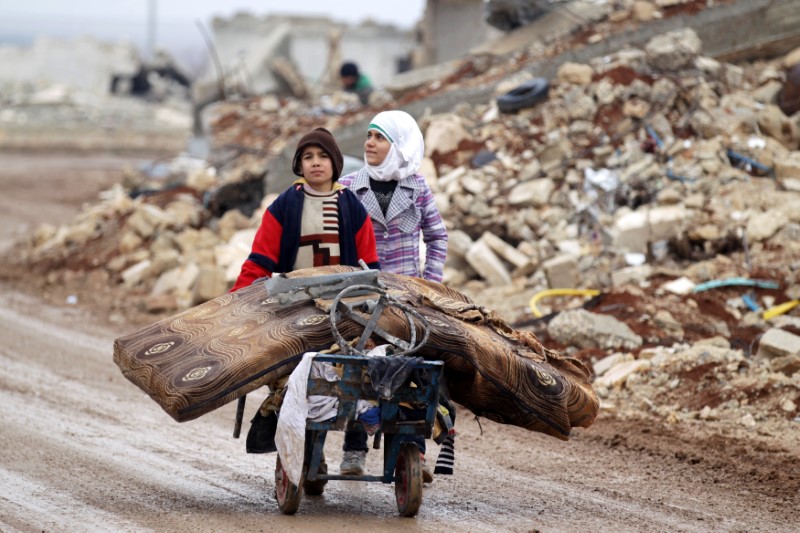 © Reuters. Samah, 11, and her brother, Ibrahim, transport their salvaged belongings from their damaged house in Doudyan village in northern Aleppo Governorate