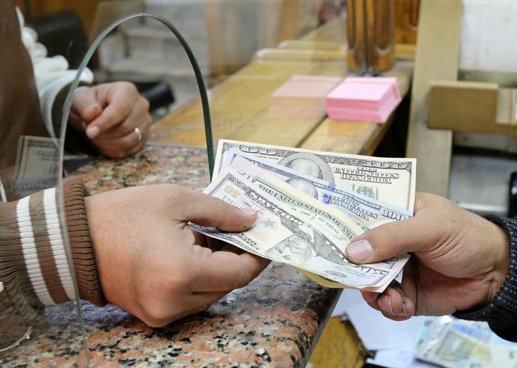 © Reuters. A customer exchanges U.S. dollars to Egyptian pounds in a foreign exchange office in central Cairo