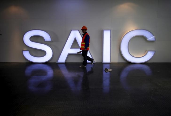 © Reuters. File photo of a worker walking past a lighted signage of the SAIC before the opening of the Shanghai International Automobile Industry Exhibition in Shanghai