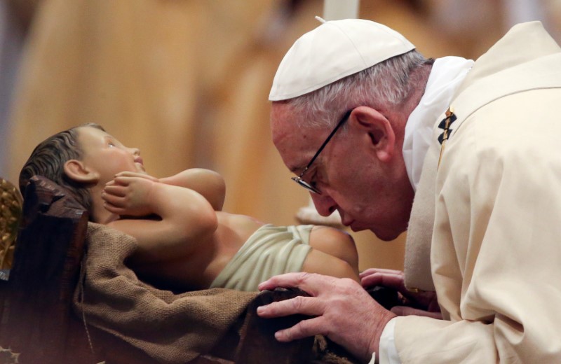 © Reuters. Papa Francisco beija estátua do menino Jesus durante missa na basília de São Pedro, no Vaticano