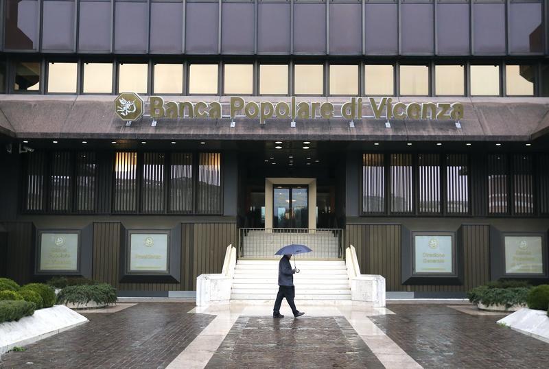 © Reuters. A person walks in front of Banca Popolare di Vicenza headquater is seen in Vicenza