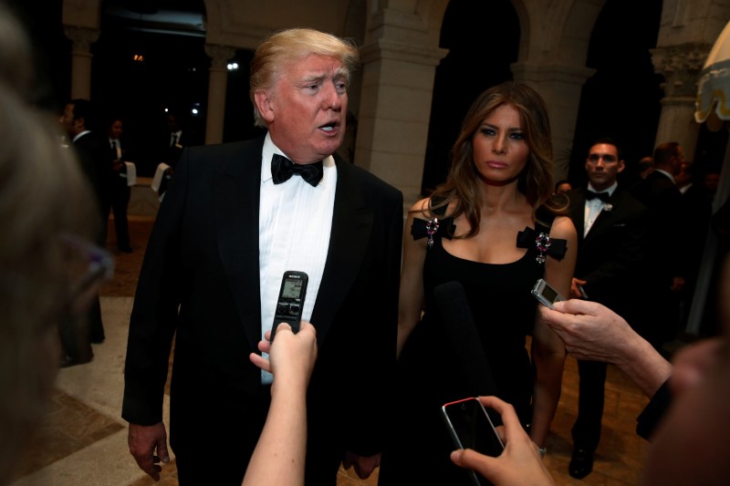 © Reuters. U.S. President-elect Donald Trump talks to reporters as he and his wife Melania Trump arrive for a New Year's Eve celebration with members and guests at the Mar-a-lago Club in Palm Beach