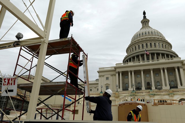 © Reuters. Workers construct the viewing stands ahead of Trump's inauguration at the U.S. Capitol in Washington