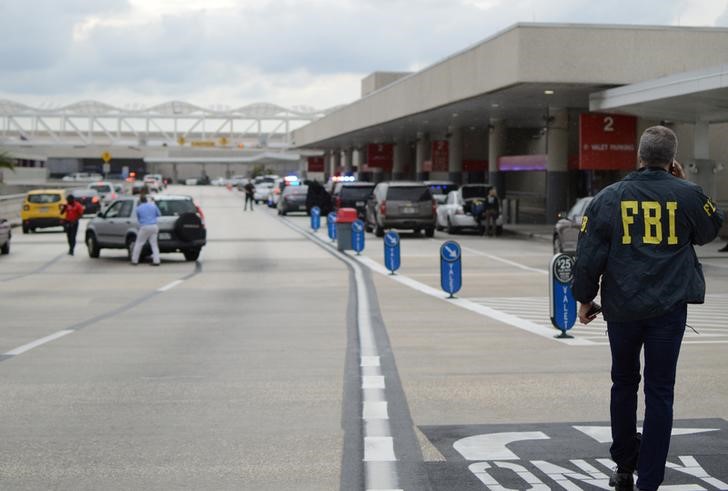 © Reuters. Autoridades caminham do lado de fora de um terminal do aeroporto de Fort Lauderdale, onde um homem abriu fogo com uma arma