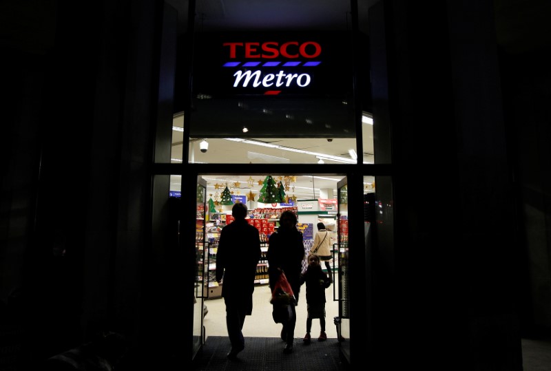 © Reuters. Customers enter and exit a Tesco shop in London