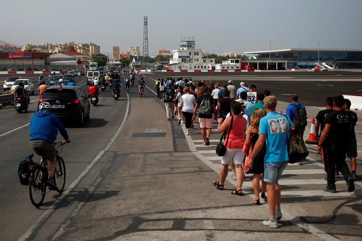 © Reuters. Pedestrians, drivers and bikers cross the tarmac at Gibraltar International Airport as they leave Gibraltar at its border with Spain, in the British overseas territory of Gibraltar