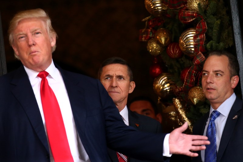 © Reuters. Incoming White House Chief of Staff Reince Priebus and U.S. Army Lieutenant General Michael Flynn look at U.S. President-elect Donald Trump as he talks with the media at Mar-a-Lago estate where Trump attends meetings, in Palm Beach, Florida