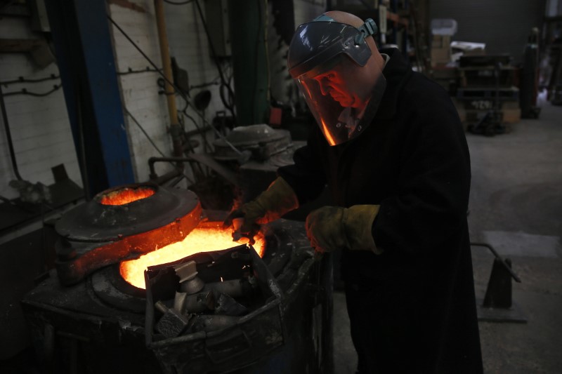 © Reuters. Foundry worker Billy Smith melts bronze to make British Academy of Film and Television Awards masks at a foundry in west London