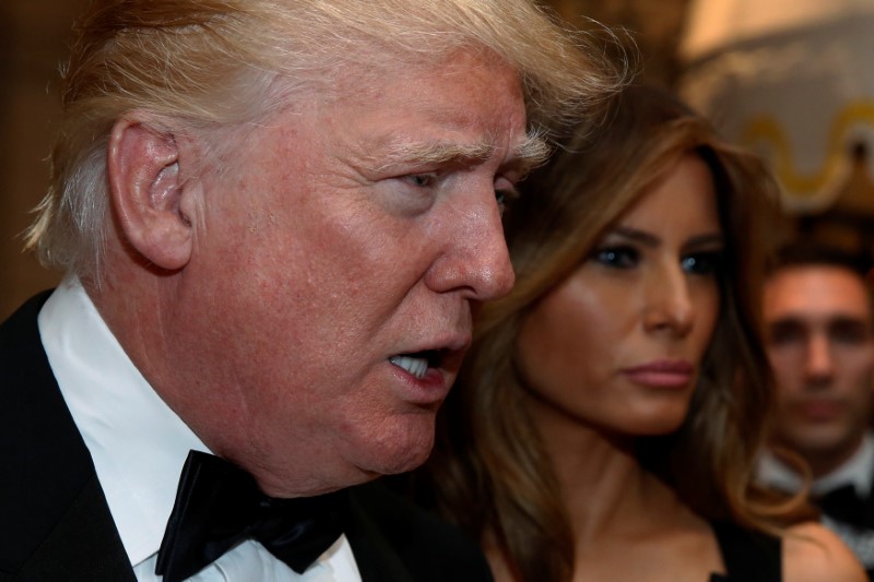 © Reuters. U.S. President-elect Donald Trump talks to reporters as he and his wife Melania Trump arrive for a New Year's Eve celebration with members and guests at the Mar-a-lago Club in Palm Beach