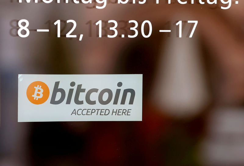 © Reuters. FILE PHOTO: A sticker reading "Bitcoin accepted here" is displayed at the entrance of the Stadthaus town hall in Zug