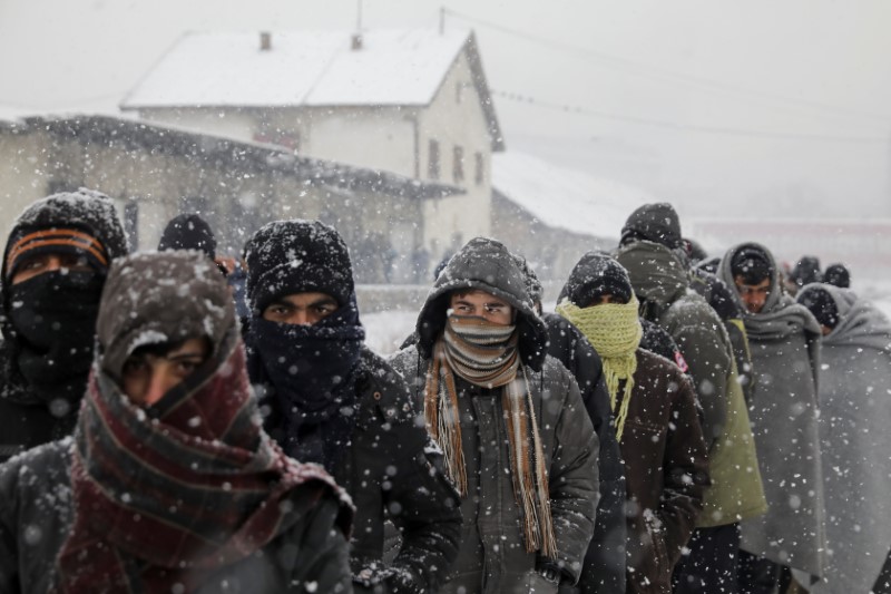 © Reuters. Imigrantes esperam em fila para receber comida durante nevasca em Belgrado, na Sérvia