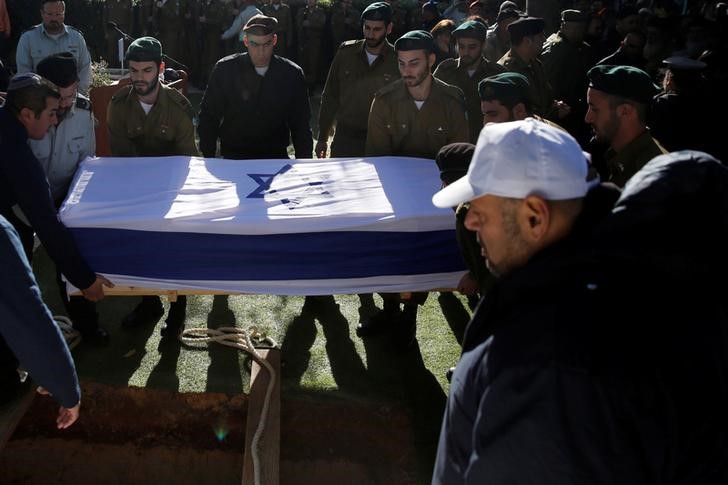 © Reuters. Soldados israelenses sepultam caixão de soldado morto em ataque realizado por um palestino com um caminhão em Jerusalém