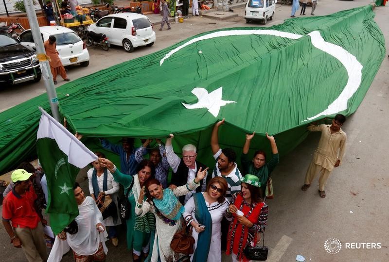 © Reuters. Supporters of civil rights group for transgender people, the Gender Interactive Alliance (GIA), dance and chant slogans as they pose with a national flag ahead of the Independence Day in Karachi, Pakistan