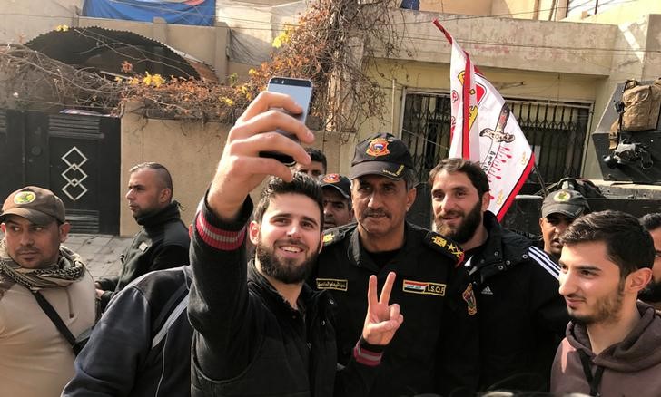 © Reuters. Jovem tira selfie com o tenente-general Abdelwahab al-Saadi no bairro de Baladiyat, no leste de Mosul