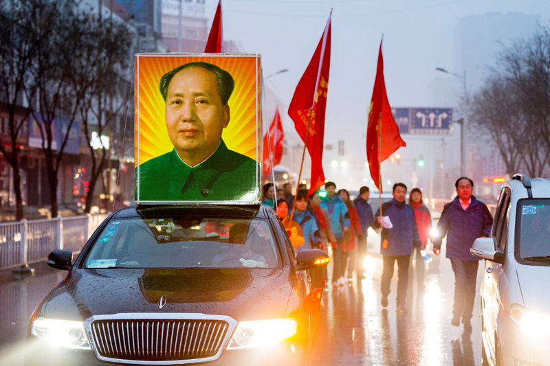 © Reuters. A picture of China's late Chairman Mao Zedong is seen on top of car as people gather to celebrate Mao's 123rd birth anniversary in Shaoshan