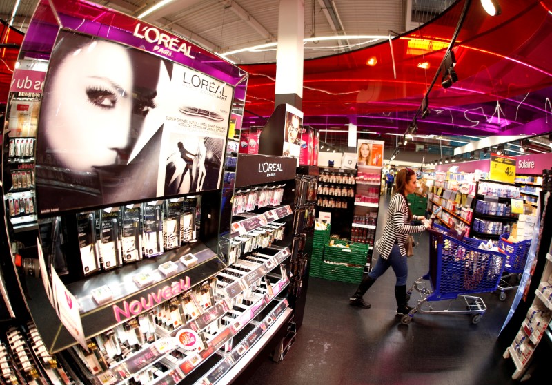 © Reuters. A customer walks past a cosmetics display of French cosmetics group L'Oreal in Nice