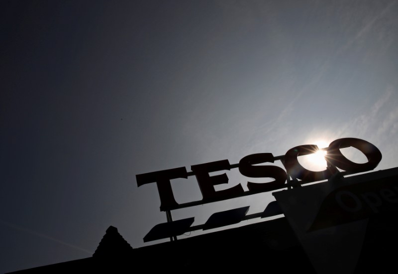 © Reuters. The signage of Tesco Extra is silhouetted against the sun in London