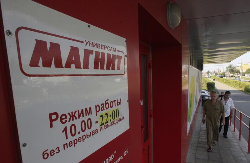 © Reuters. People walk to enter a grocery store owned by Russian retailer Magnit on the suburbs of Moscow